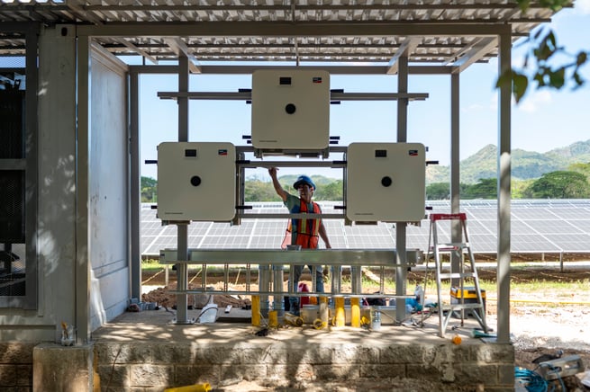 Técnico revisando inversores solares en sistema fotovoltaico industrial instalado por HiPower en Costa Rica.